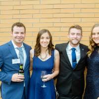 Guests posing in front of a brick wall at Enrichment.
